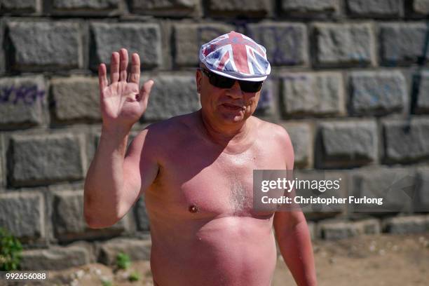 Russian man wearing a Union flag hat sunbathes on the beach next to the River Volga on July 6, 2018 in Samara, Russia. Football fans from England and...