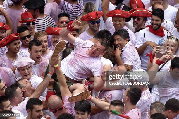 Participants celebrate during the 'Chupinazo' to mark the kickoff at noon sharp of the San Fermin Festival, in front of the Town Hall of Pamplona,...