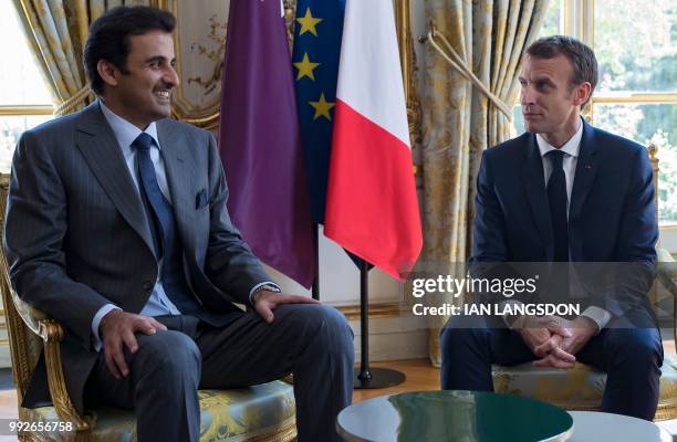 French President Emmanuel Macron speaks with the Emir of Qatar Sheikh Tamim bin Hamad Al Thani at the Elysee Palace in Paris on July 6, 2018.