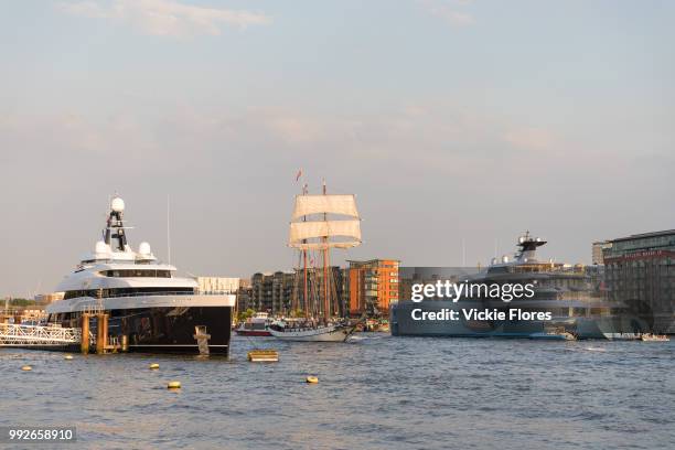 Tall ship sails past the brand new 74.5m long superyacht, Elandess, seen moored at HMS President on the River Thames on July 05, 2018 after making...