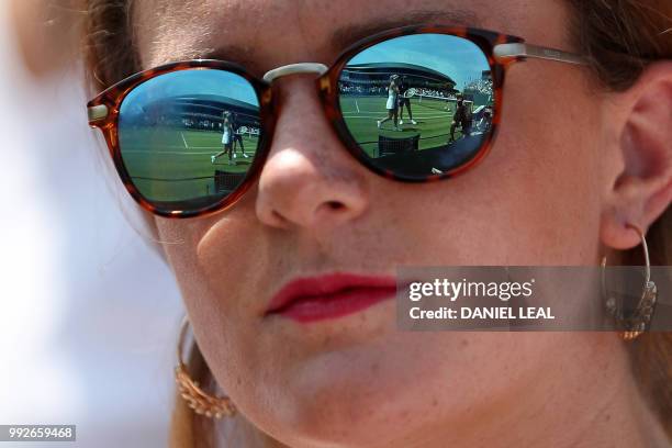 Italy's Camila Giorgi is reflected in a spectator's sunglasses as she plays against Czech Republic's Katerina Siniakova during their women's singles...