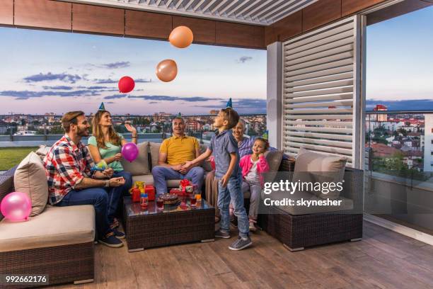 familia feliz divertirse durante la fiesta de cumpleaños en un patio de penthouse. - penthouse girl fotografías e imágenes de stock