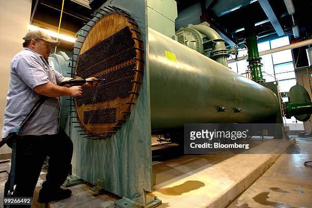 Tom Fitzpatrick cleans water tubes on the condenser of the number 7 water chiller at the Central Plant in Sacramento, California, U.S., on Monday,...