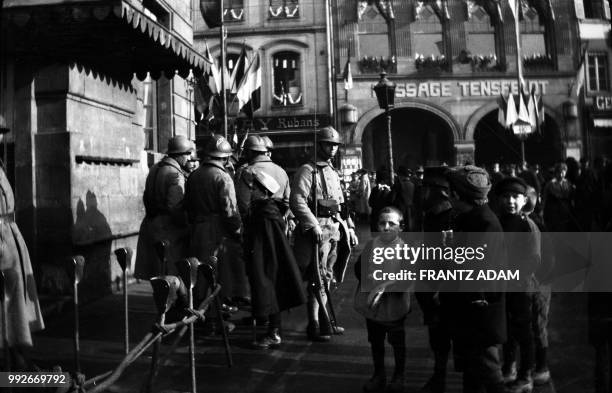 Group of chidren watch a French soldier who stands guard in a street decorated with flags, near the statue of Kleber, in Strasbourg, eastern France,...