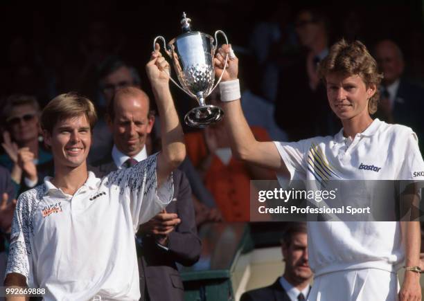 Todd Woodbridge of Australia and Helena Sukova of the Czech Republic lift the trophy after defeating TJ Middleton and Lori McNeil both of the USA in...