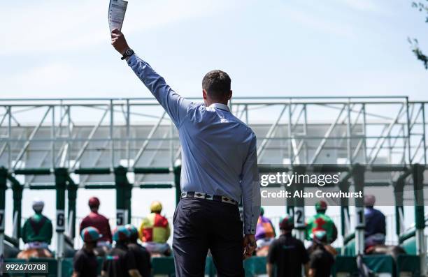 The assistant starter gives the all clear at Sandown Park on July 6, 2018 in Esher, United Kingdom.