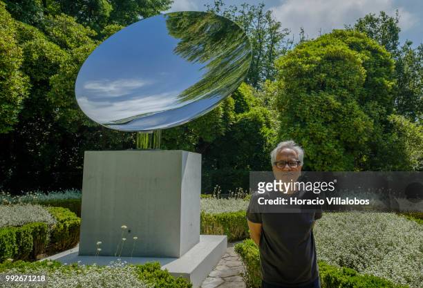 Indian artist Anish Kapoor stands in front of his work Sky Mirror during the presentation to the press of his exhibition "Anish Kapoor: Works,...