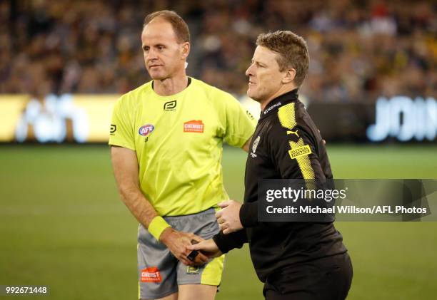 Damien Hardwick, Senior Coach of the Tigers and Umpire Dean Margetts shake hands during the 2018 AFL round 16 match between the Richmond Tigers and...