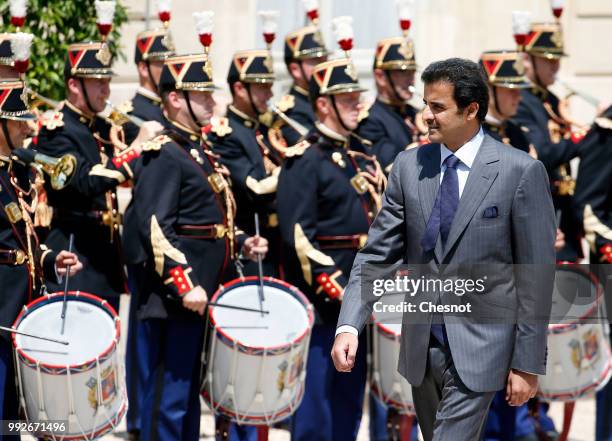 Qatar's Emir Sheik Tamim bin Hamad al-Thani walks past the honor guard as he arrives for a meeting with French President Emmanuel Macron at the...