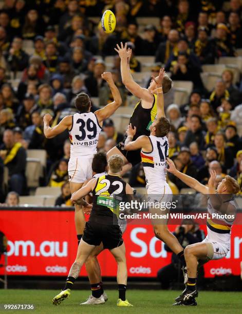 Jack Riewoldt of the Tigers attempts a spectacular mark over Kyle Hartigan of the Crows during the 2018 AFL round 16 match between the Richmond...