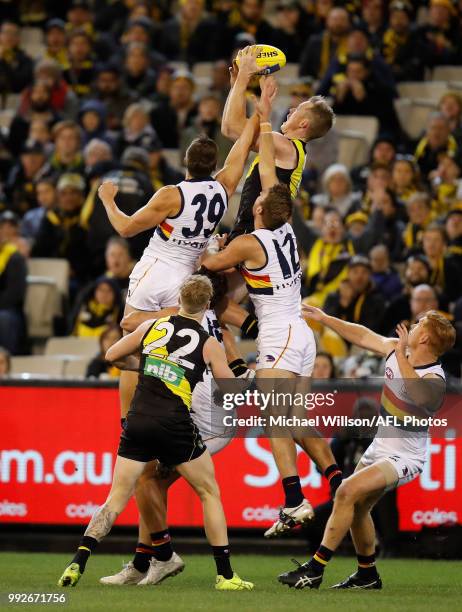 Jack Riewoldt of the Tigers attempts a spectacular mark over Kyle Hartigan of the Crows during the 2018 AFL round 16 match between the Richmond...