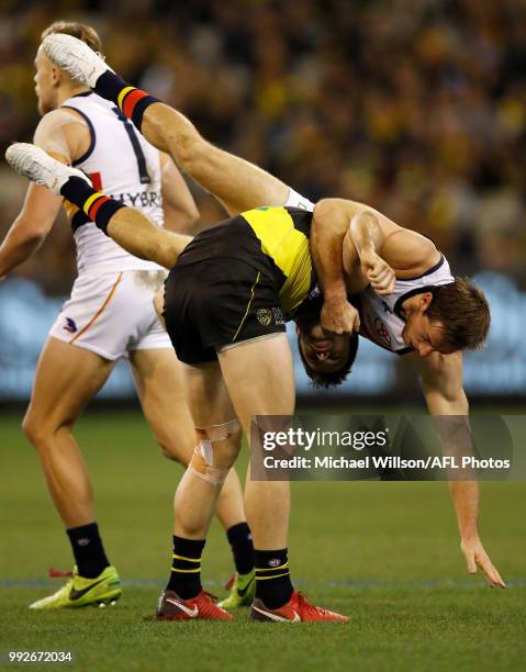 Trent Cotchin of the Tigers and Richard Douglas of the Crows struggle during the 2018 AFL round 16 match between the Richmond Tigers and the Adelaide...