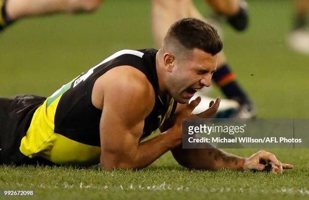 Jack Graham of the Tigers reacts after an shoulder injury during the 2018 AFL round 16 match between the Richmond Tigers and the Adelaide Crows at...