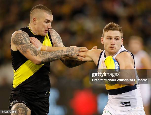 Rory Laird of the Crows fends off Dustin Martin of the Tigers during the 2018 AFL round 16 match between the Richmond Tigers and the Adelaide Crows...