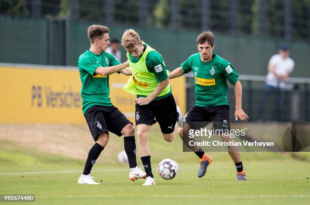 Patrick Herrmann, Andreas Poulsen and Jonas Hofmann battle for the ball during a training session of Borussia Moenchengladbach at Borussia-Park on...