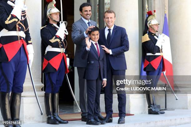 French president Emmanuel Macron , Qatar Sheikh Tamim bin Hamad Al Thani and his son Hamad pose upon arrival at the Elysee palace on July 6 in Paris.