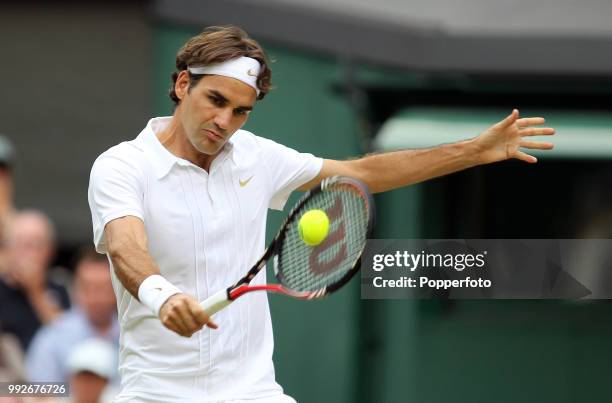 Roger Federer of Switzerland returns the ball against Arnaud Clément of France in the Mens Singles third round on day five of the 2010 Wimbledon...