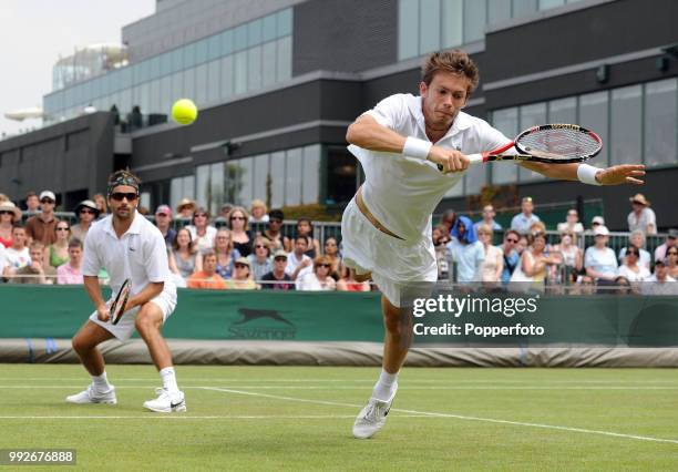 Nicolas Mahut of France flies through the air in an attempt to reach a shot from British pair Colin Fleming & Ken Skupski in the Mens Doubles first...