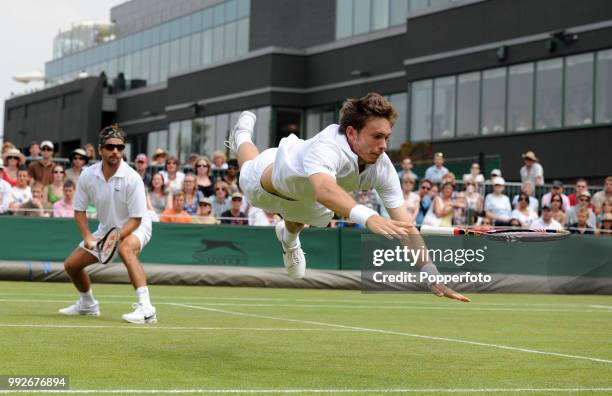 Nicolas Mahut of France flies through the air in an attempt to reach a shot from British pair Colin Fleming & Ken Skupski in the Mens Doubles first...