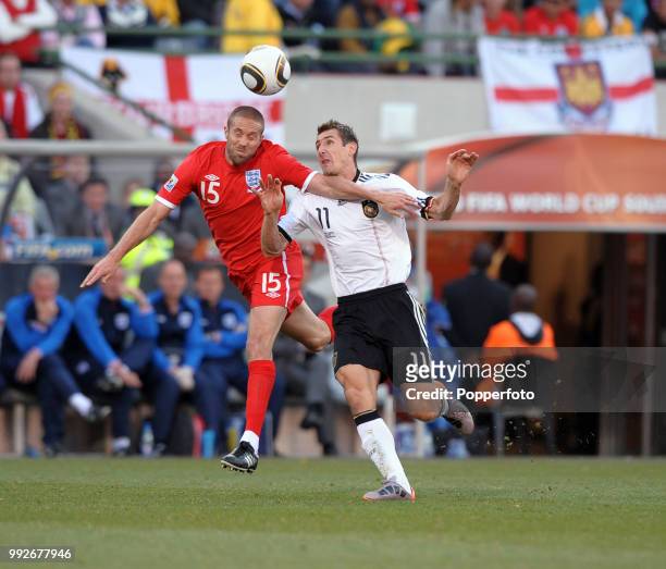 Matt Upson of England and Miroslav Klose of Germany battle for the ball during a FIFA World Cup Round of 16 match at the Free State Stadium on June...
