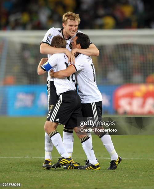 Philipp Lahm of Germany and Piotr Trochowski (15 celebrate with teammate Per Mertesacker after the FIFA World Cup Round of 16 match between Germany...