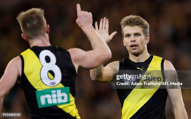 Dan Butler of the Tigers congratulates Jack Riewoldt of the Tigers on a goal during the 2018 AFL round 16 match between the Richmond Tigers and the...