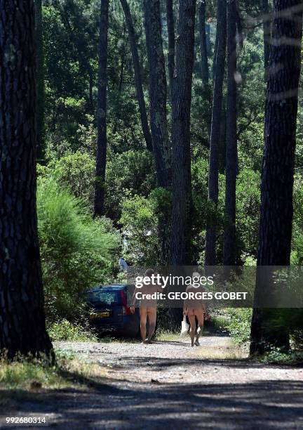 Graphic content / A naked couple walks on a path at the Arnaoutchot naturist camping on June 26, 2018 in Vielle-Saint-Girons, southwestern France. -...