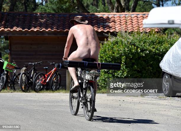 Graphic content / A naked person rides a bicycle at the Arnaoutchot naturist camping on June 26, 2018 in Vielle-Saint-Girons, southwestern France. -...