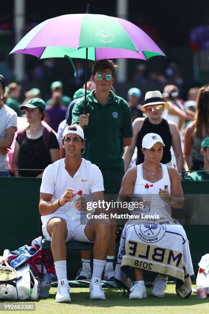 Thanasi Kokkinakis and Ashleigh Barty of Australia look on during a break in play against Fabrice Martin of France and Raluca Olaru of Romania in...