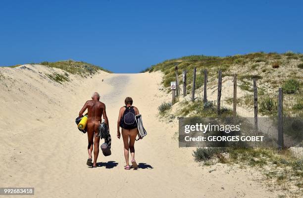 Graphic content / Naked people walk to the beach of the Arnaoutchot naturist camping on June 26, 2018 in Vielle-Saint-Girons, southwestern France. -...