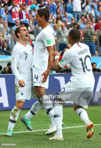 Raphael Varane of France celebrates with team mates Kylian Mbappe and Antoine Griezmann after scoring his team's first goal during the 2018 FIFA...