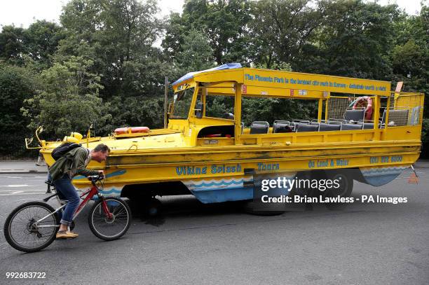 Cyclist stops to look at a Viking Splash tour bus sits outside the Shelbourne Hotel on St. Stephen's Green in Dublin after one of it's wheels came...