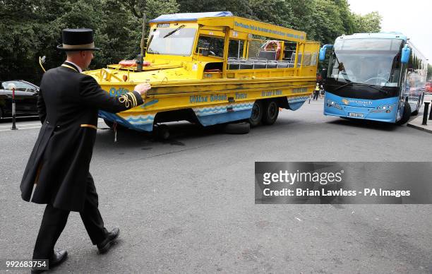 Doorman helps direct traffic as a Viking Splash tour bus sits outside the Shelbourne Hotel on St. Stephen's Green in Dublin after one of it's wheels...