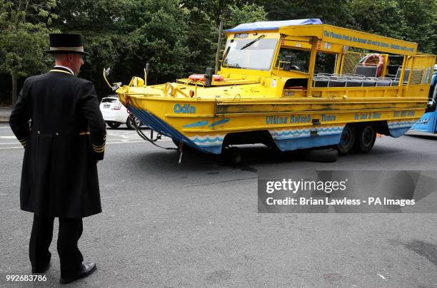 Doorman looks at a Viking Splash tour bus outside the Shelbourne Hotel on St. Stephen's Green in Dublin after one of it's wheels came off.