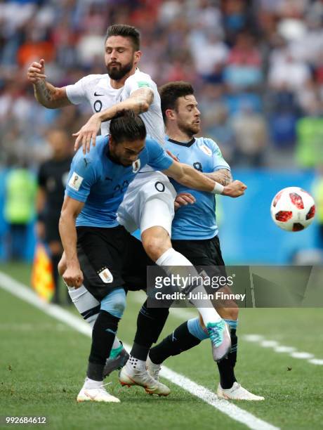Olivier Giroud of France clashes with Martin Caceres and Nahitan Nandez of Uruguay during the 2018 FIFA World Cup Russia Quarter Final match between...