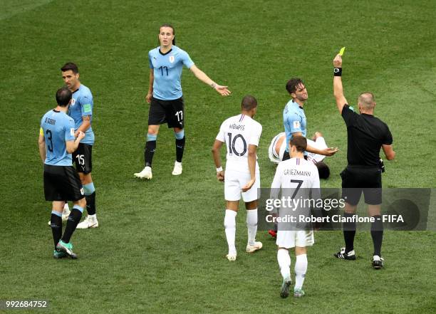 Rodrigo Bentancur of Uruguay is shown a yellow card by referee Nestor Pitana during the 2018 FIFA World Cup Russia Quarter Final match between...