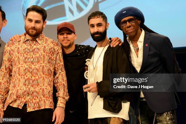 Rudimental, winners of the Bose Innovation Award and presenter Nile Rodgers on stage during the Nordoff Robbins' O2 Silver Clef Awards ceremony at...