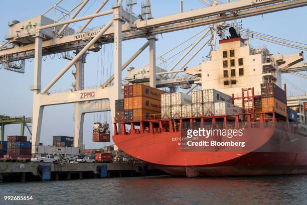 Shipping containers are unloaded from the Hamburg Sud North America Inc. Cap Capricorn cargo ship at the Port of Oakland in Oakland, California,...