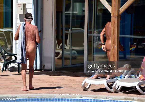 Graphic content / Naked people walk next to a swimming pool as a person takes a sunbath at the Arnaoutchot naturist camping on June 26, 2018 in...