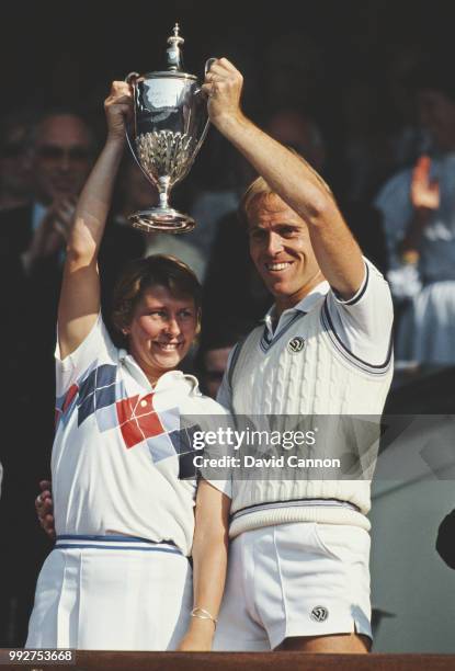 John Lloyd of Great Britain and Wendy Turnbull of Australia lift their wiinning trophy's after defeating Steve Denton and Billie Jean King of the...