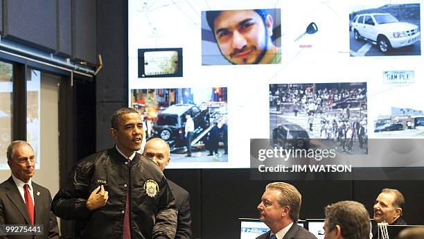 President Barack Obama tries on his New York Police Department jacket while touring the Real Time Crime Center at police headquarters with New York...