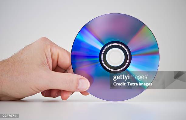 hand holding compact disc - dvd fotografías e imágenes de stock