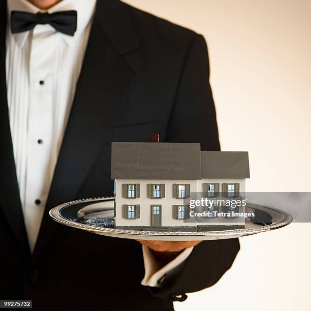 butler holding toy house on tray - silver platter stock pictures, royalty-free photos & images