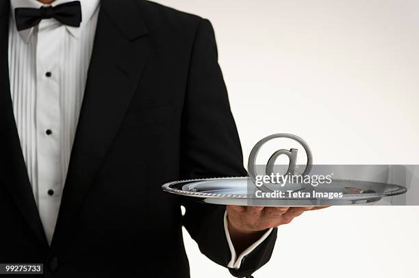 butler holding at symbol on silver tray - silbertablett stock-fotos und bilder