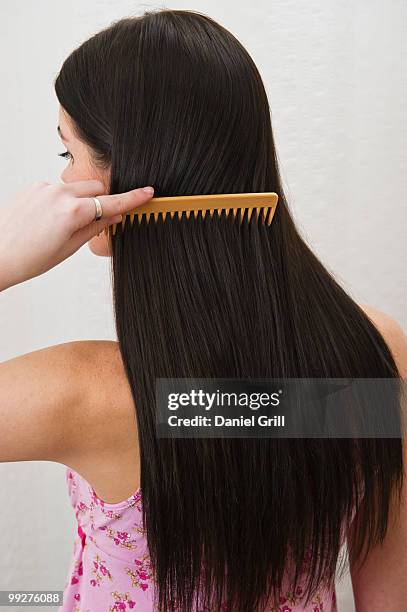 woman combing her hair - brushing hair stock-fotos und bilder