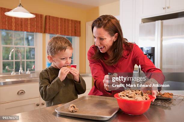 mother and son baking cookies - mark atkinson stock pictures, royalty-free photos & images