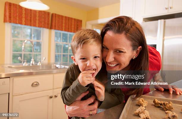 mother and son baking cookies - mark atkinson stock pictures, royalty-free photos & images