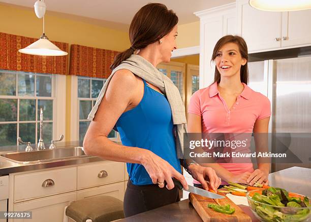 mother and daughter in kitchen - mark atkinson stock pictures, royalty-free photos & images