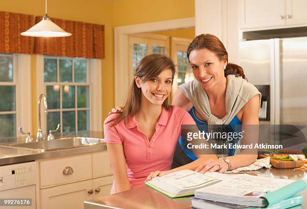 mother and daughter in kitchen - mark atkinson stock pictures, royalty-free photos & images