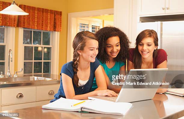 friends looking at laptop - mark atkinson stock pictures, royalty-free photos & images